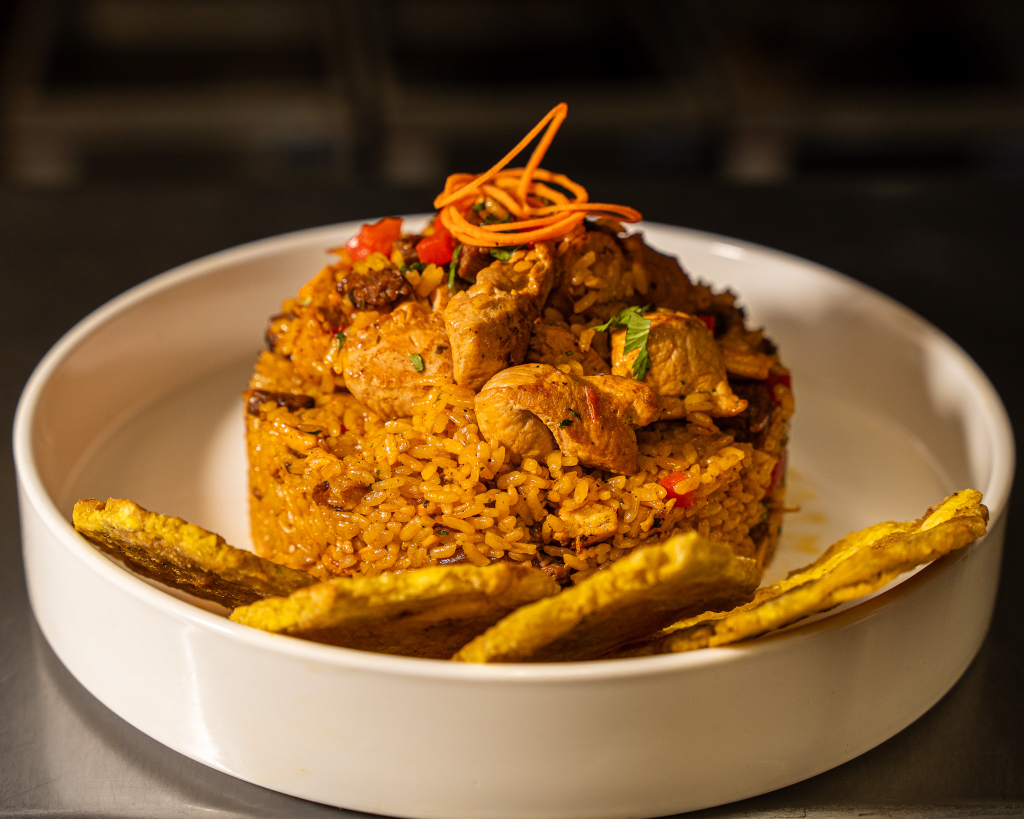 Arroz Jíbaro — Stir-fried rice with longaniza sausage, pork, chicken, and skirt steak served with green plantains.